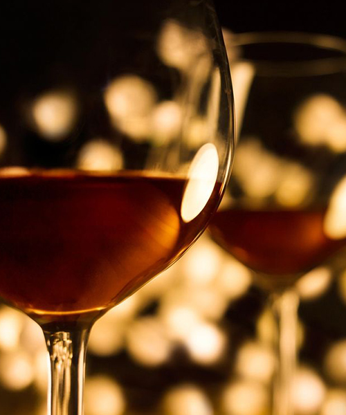 Two glasses of wine, in front of blurred lights