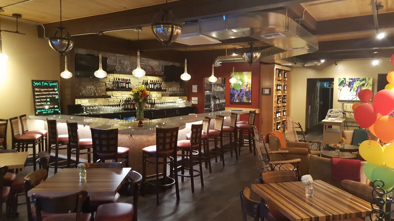 The inside of The Melody Lynne Vineyard Wine Bar, with tables and bar seating