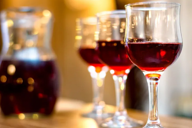 three wine glasses with red wine